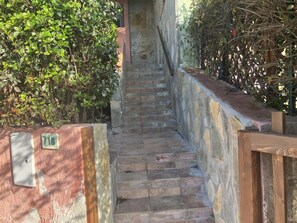 A stone staircase leading up to a door, surrounded by dense foliage. - Beautiful sea view:  Lovely 3-bedroom house with AC in charming Porto Tramatzu` (Porto Tramatzu)