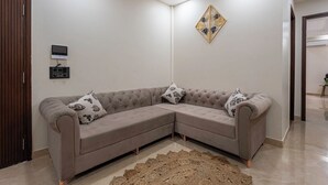 Ein modernes Wohnzimmer mit einer Eckcouch, einer Wanddekoration und einer integrierten Unterhaltungsanlage.