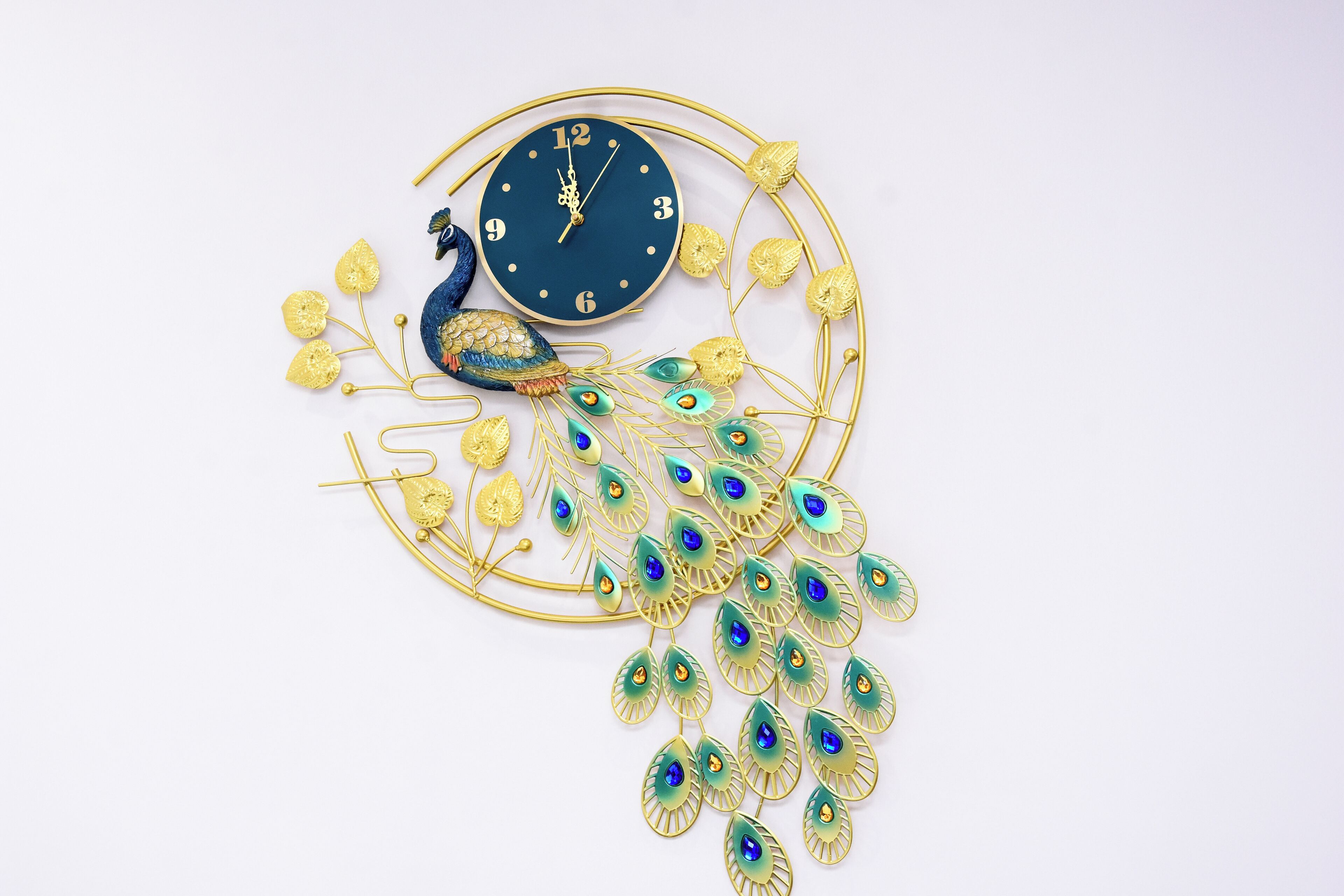 A decorative clock with peacock motifs and gold accents.