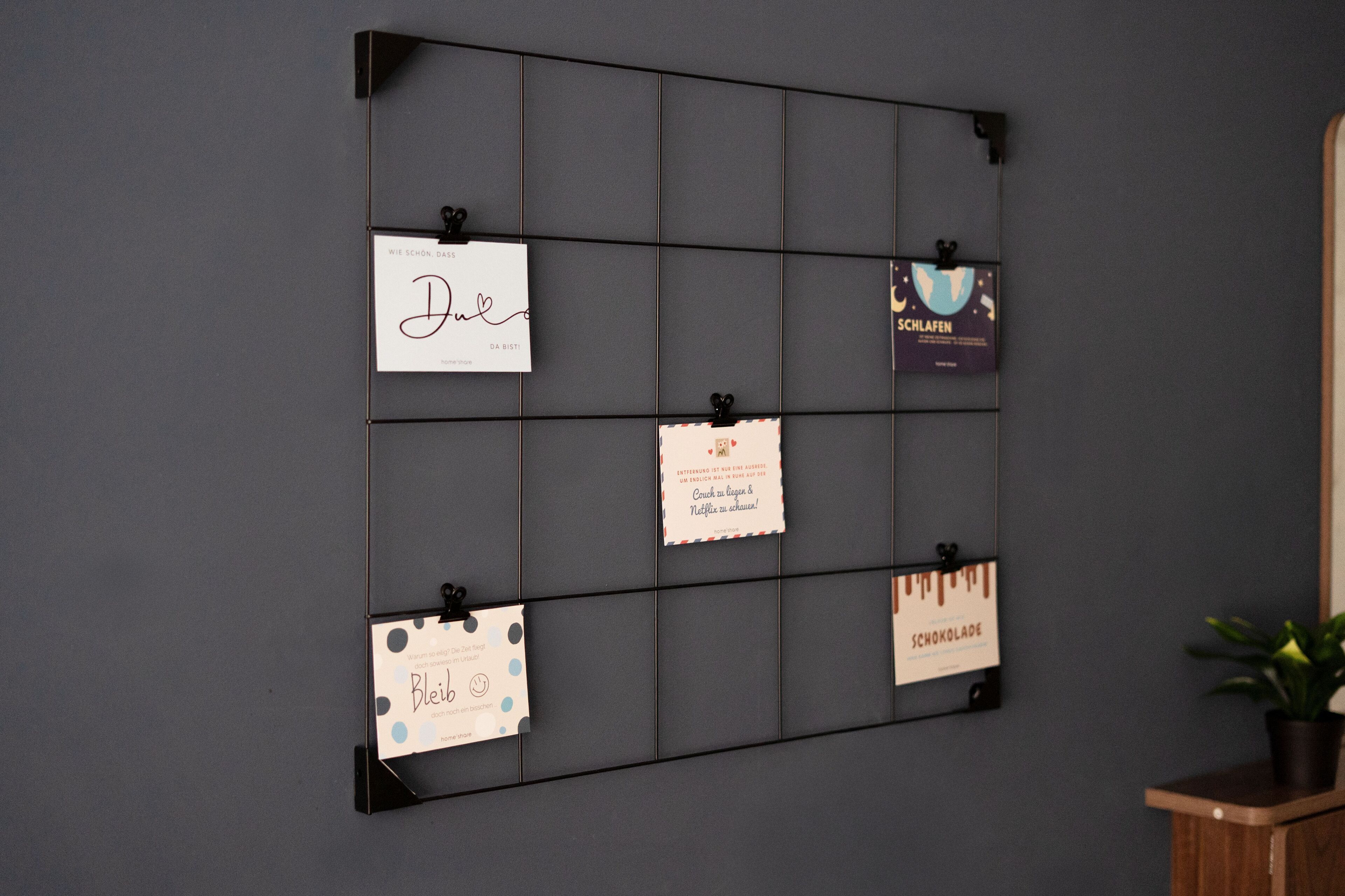 Een prikbord aan de muur met verschillende kaartjes eraan vastgemaakt, waaronder een met de tekst 'Bleil' en een andere met 'Schokolade'.