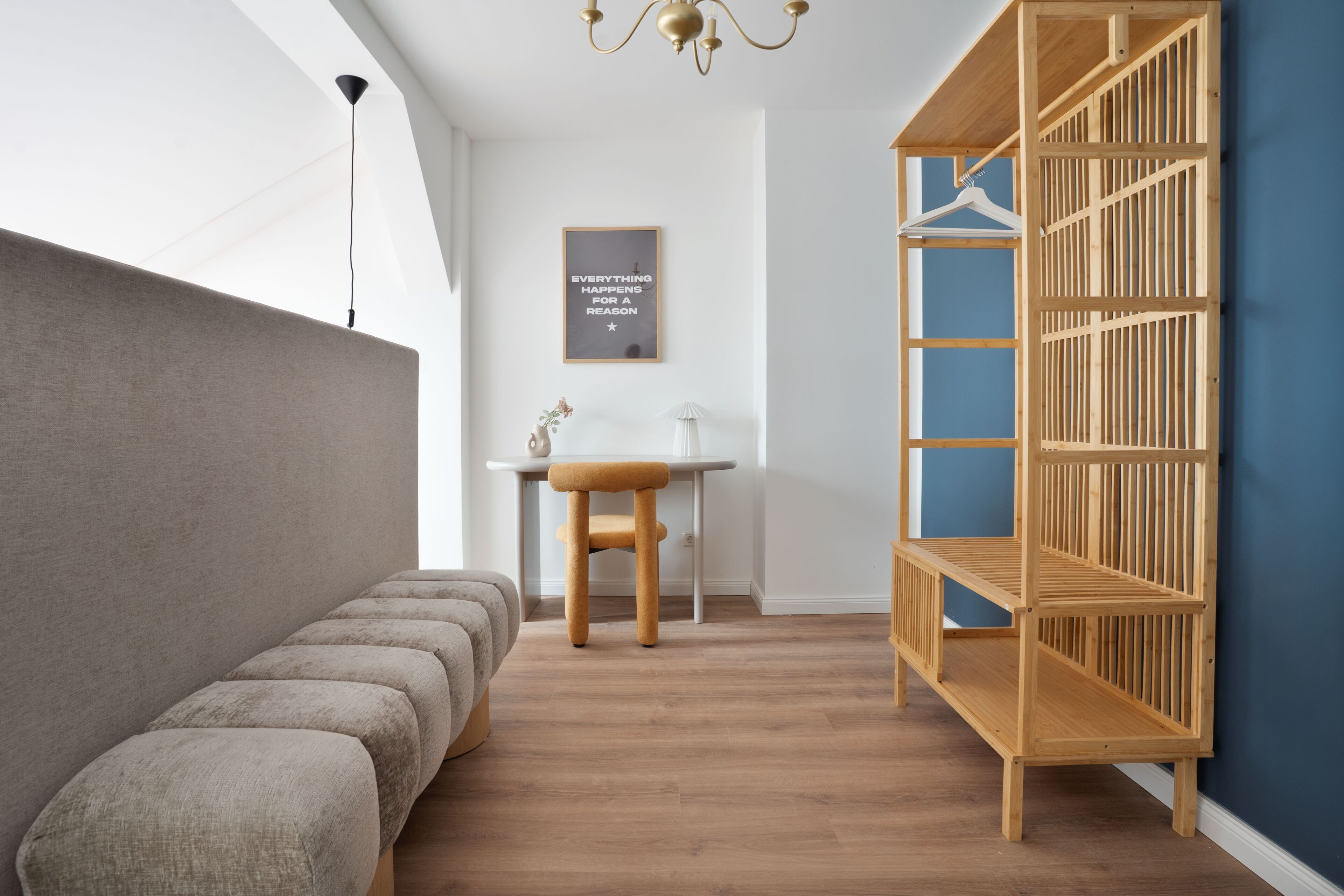 A modern room with a bench, a wooden shelf, a table, and a wall-mounted light fixture.