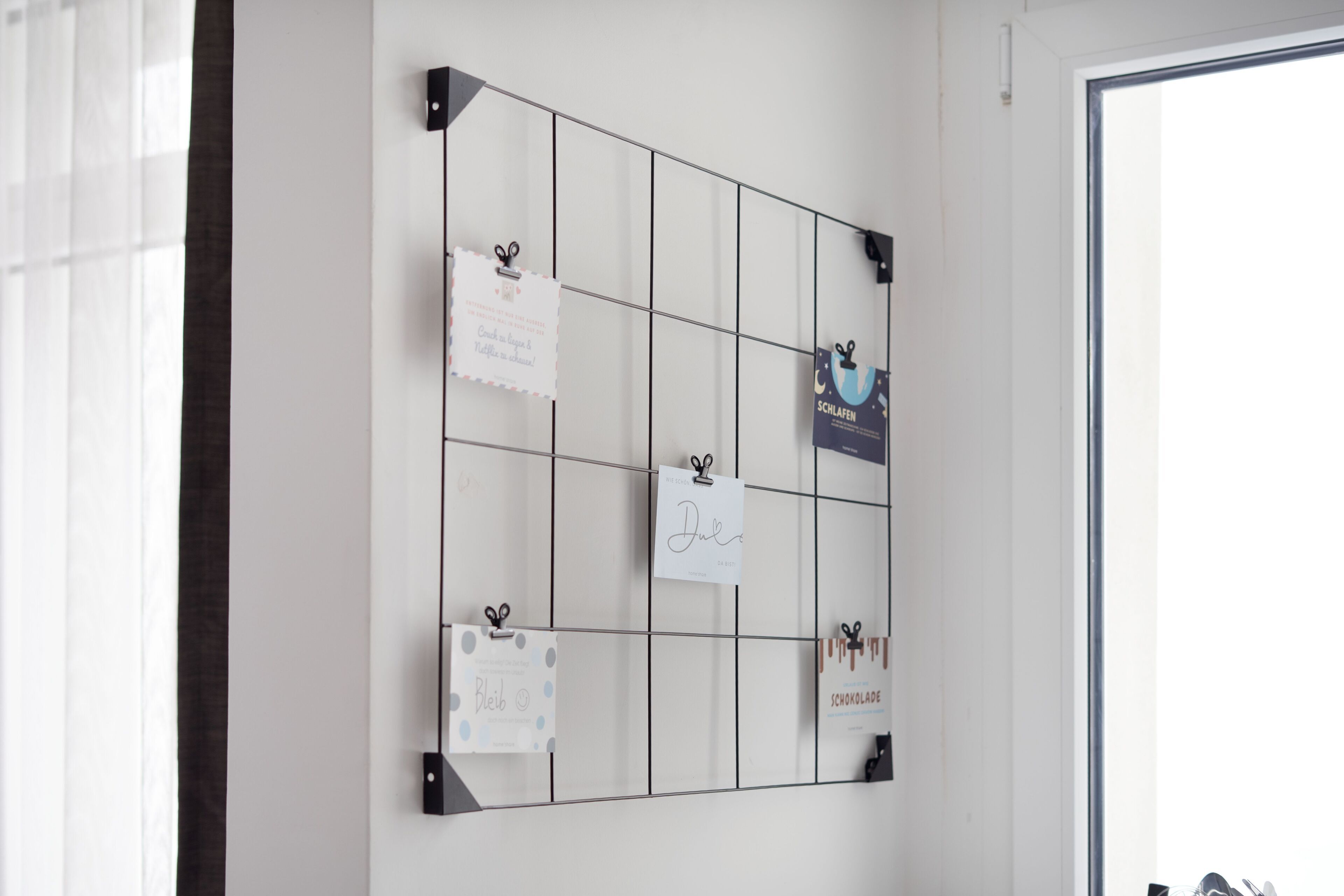 A wall with a grid of hooks holding various items.