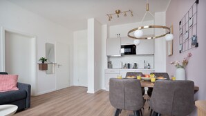 Eine moderne Küche mit Mikrowelle, Spüle und Essbereich mit Stühlen und Tisch.