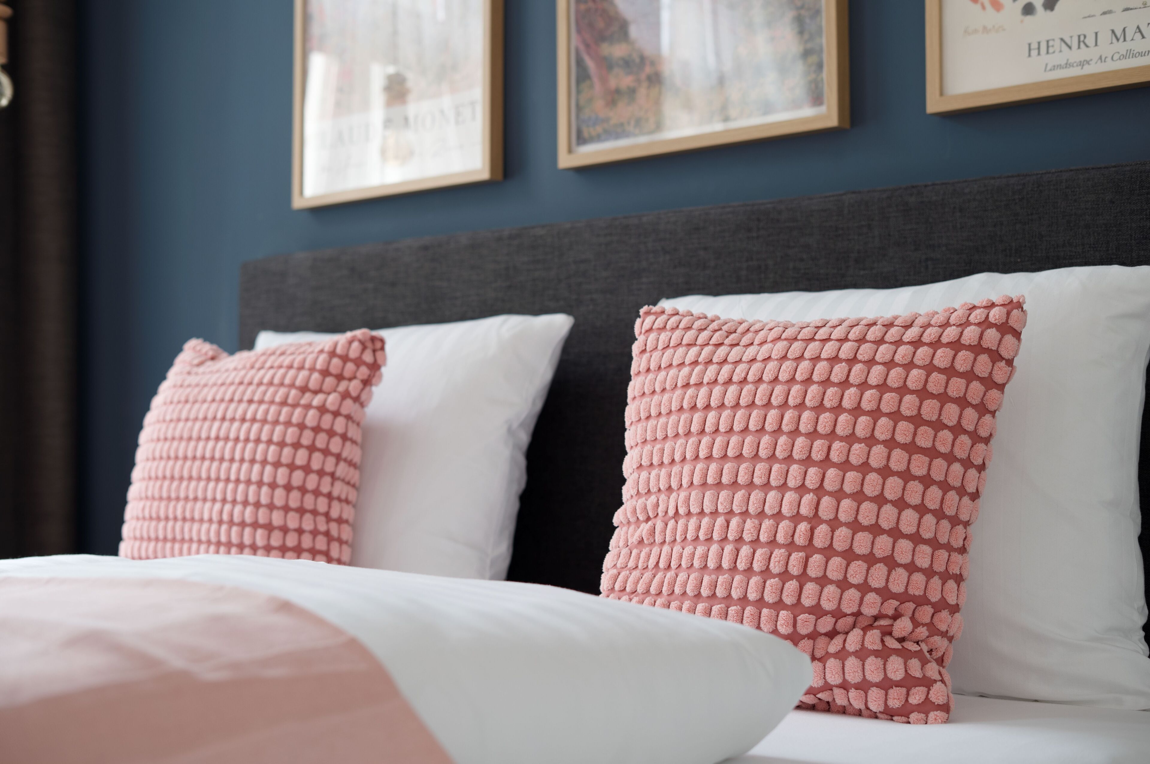 Un dormitorio con una cama, dos almohadas y un cabecero.