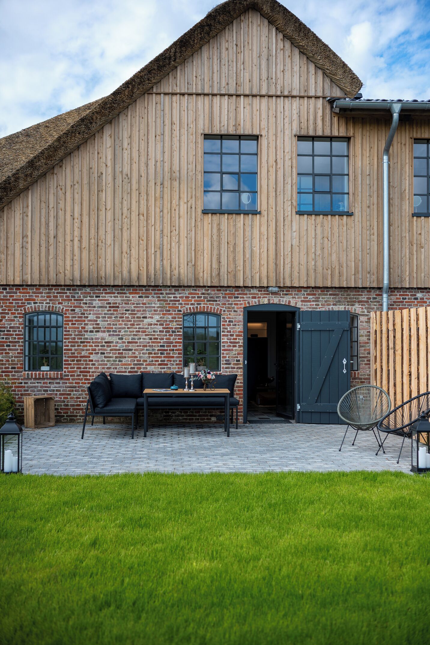 Un edificio in stile colonico, con una base in mattoni e pareti superiori in legno.