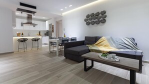 Una sala moderna con un sofá, una mesa de centro y una zona de comedor con sillas y una mesa.