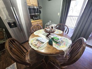 A dining table with chairs, a water dispenser, a microwave, and a cabinet in the background. - Apple Valley  53 at Rumbling Bald (Lake Lure)