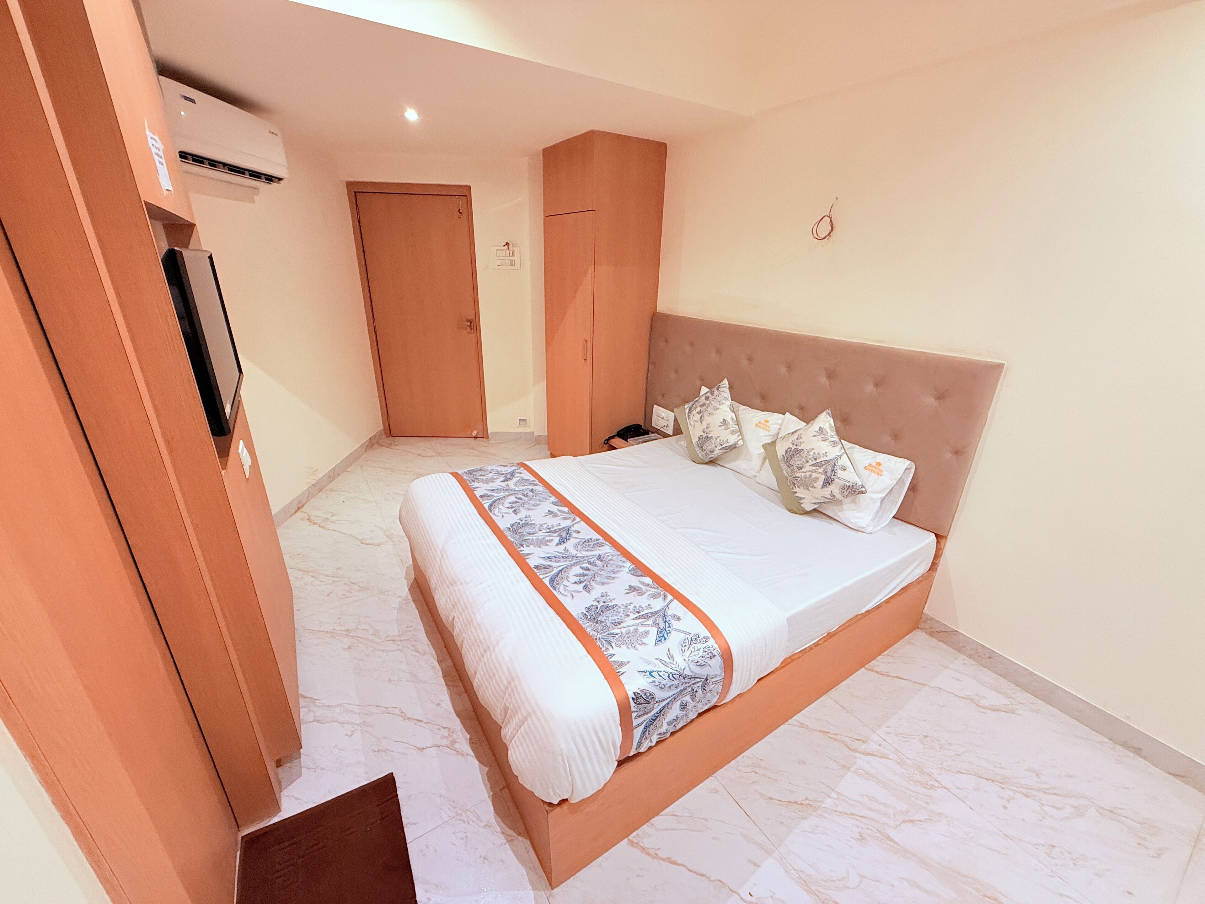 Um quarto com uma cama, um guarda-roupa e um ar condicionado.
