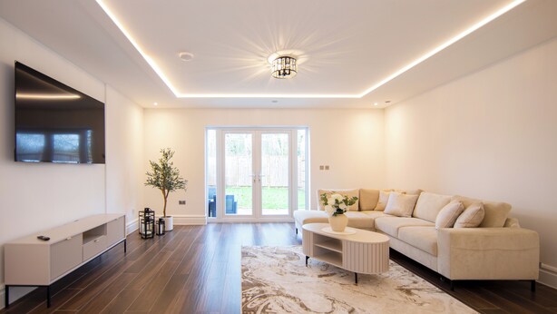 A modern living room with a sofa, coffee table, and TV. - Beautiful 4 Bed House - Close to Windsor Castle! (Windsor)