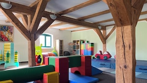 Zona de juegos con bloques de espuma de colores y una ventana.
