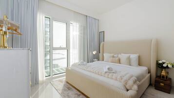 A modern bedroom with a large bed, a wardrobe, a nightstand, and a view of the outside.