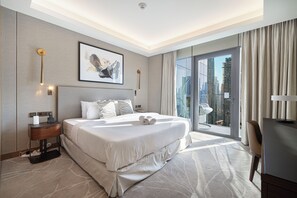 A modern hotel room with a large bed, a bedside table with a lamp, a view of the city through a large window, and a cityscape view from the balcony. - Address Opera by NAMUVE (Dubai)