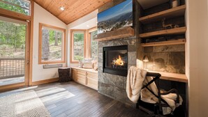 A modern living room with a fireplace, wooden shelves, and large windows. - Easy Living at Northstar by Tahoe Getaways - 4BR Pet Friendly w/ Ski Shuttle & HOA (Truckee)