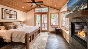 A bedroom with a bed, wooden ceiling, a fireplace, and a TV. - Easy Living at Northstar by Tahoe Getaways - 4BR Pet Friendly w/ Ski Shuttle & HOA (Truckee)