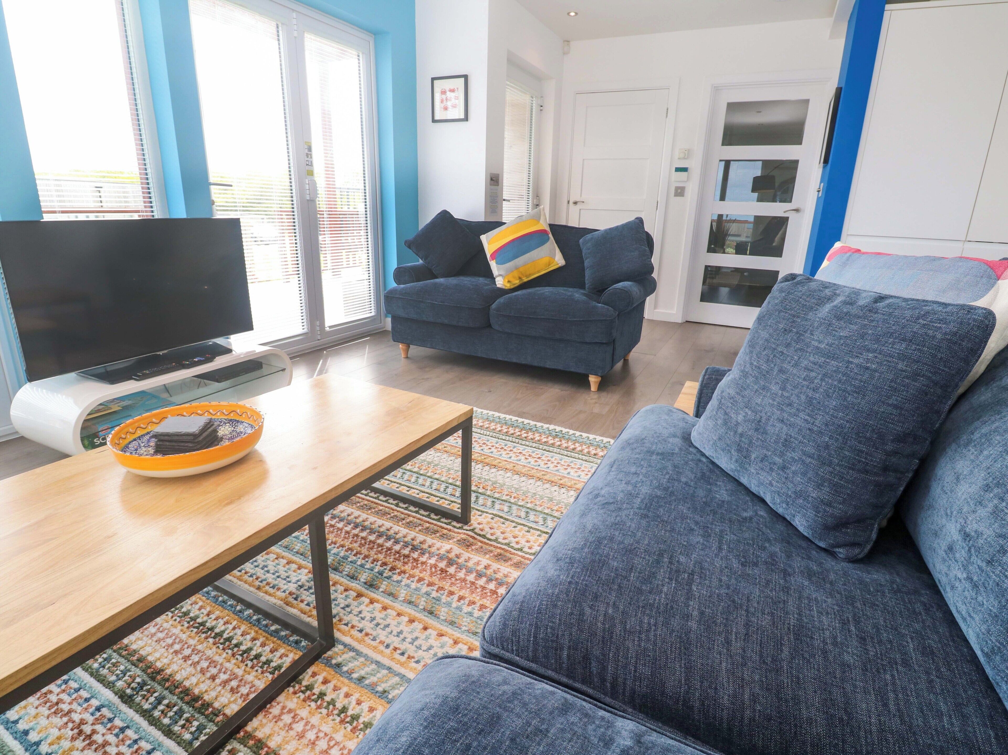 A living room with a sofa, a television, and a coffee table.