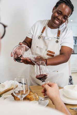 Eine Person schenkt Wein in ein Glas ein.