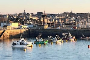 A harbor with several boats docked, a cityscape in the background, and a bridge on the left. - Quiet studio within the city walls, 150m from the beach (Saint-Malo)