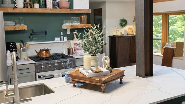 A modern kitchen with a central island, wooden ceiling, and pendant lighting.