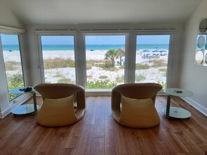 A room with two chairs facing a large window overlooking a beach. - 1017 - Premium - Beach Front (Siesta Key)