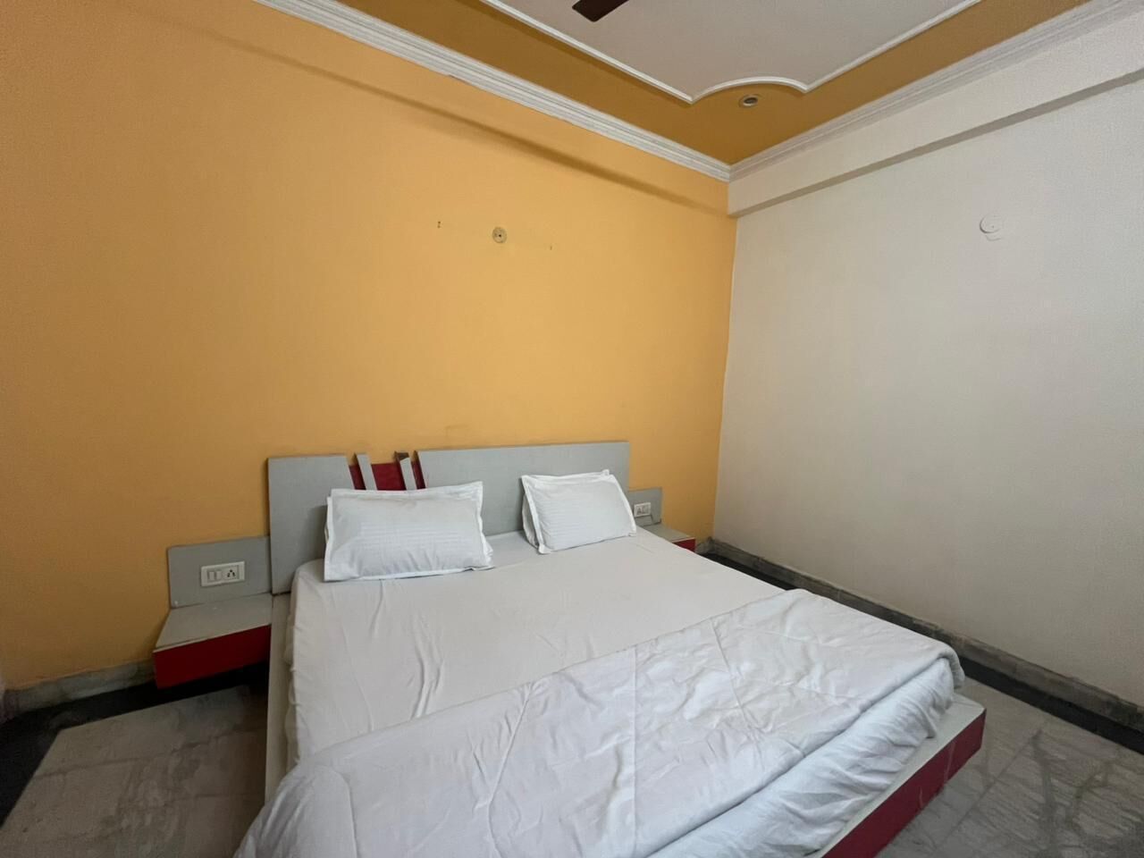 Ein Hotelzimmer mit Bett, Nachttisch und Wandleuchte.