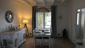 Un comedor con una mesa blanca, sillas, un reloj y una lámpara.