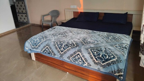 A bedroom with a bed, a chair, and a patterned bedspread. - Fortune Heritage Resort  (Shri Madhopur)
