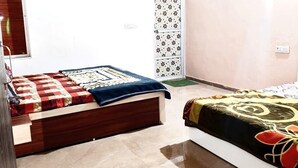 A bedroom with two beds, each with a distinct patterned bedspread. - Fortune Heritage Resort  (Shri Madhopur)