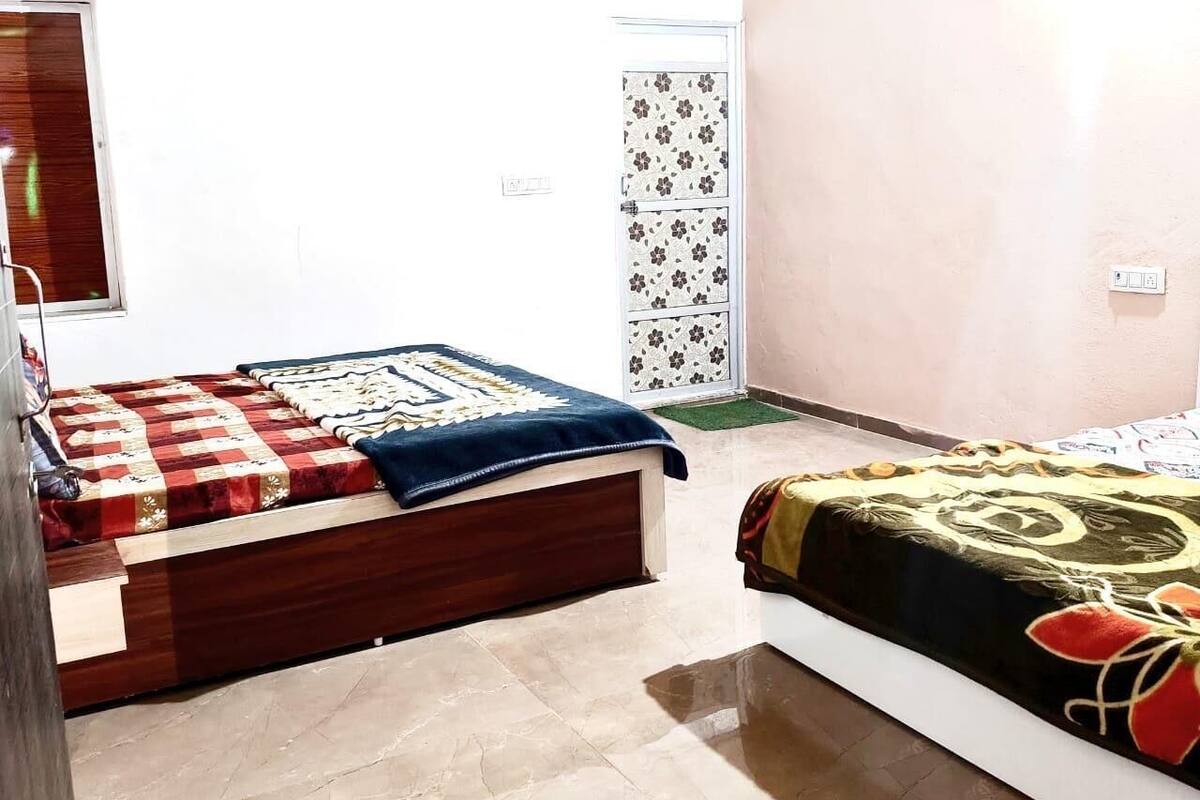 Un dormitorio con dos camas, cada una con un edredón de diseño diferente.