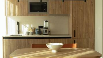 Een koelkast met diepvriezer, een microgolfoven, een oven, een kookplaat