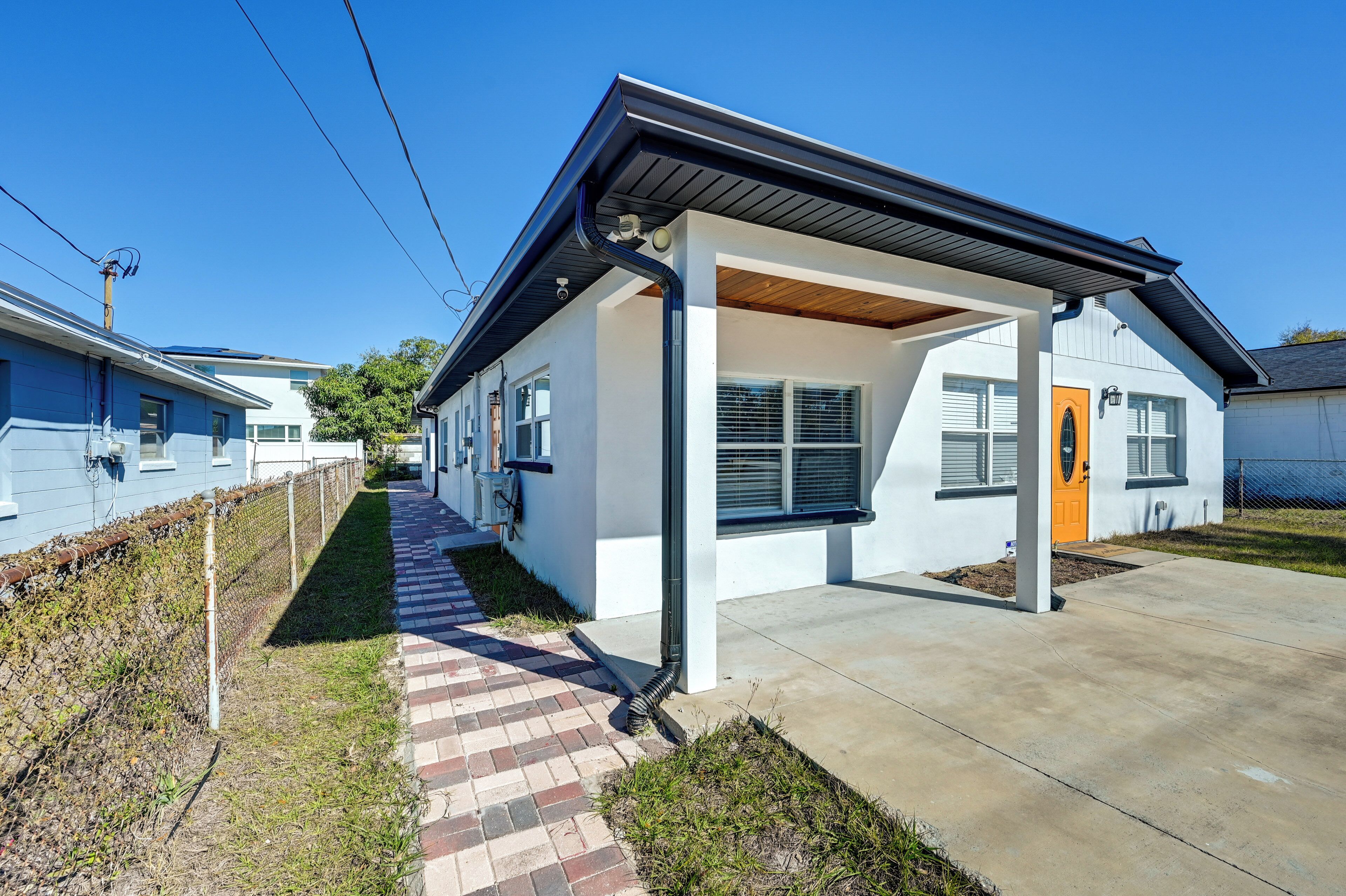 A modern single-story house with a covered porch, a brick pathway, and a well-maintained lawn.