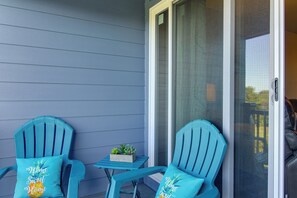 A balcony with two turquoise Adirondack chairs, a small table, and a planter with succulents. - Relax & Unwind by the Sea! Unit in Ocean Shores (Ocean Shores)