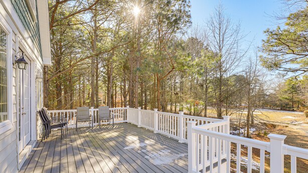 A wooden deck with white railings, a bench, and a table. - 1 Mi to Bethany Beach: Family Home on Golf Course! (Bethany Beach)