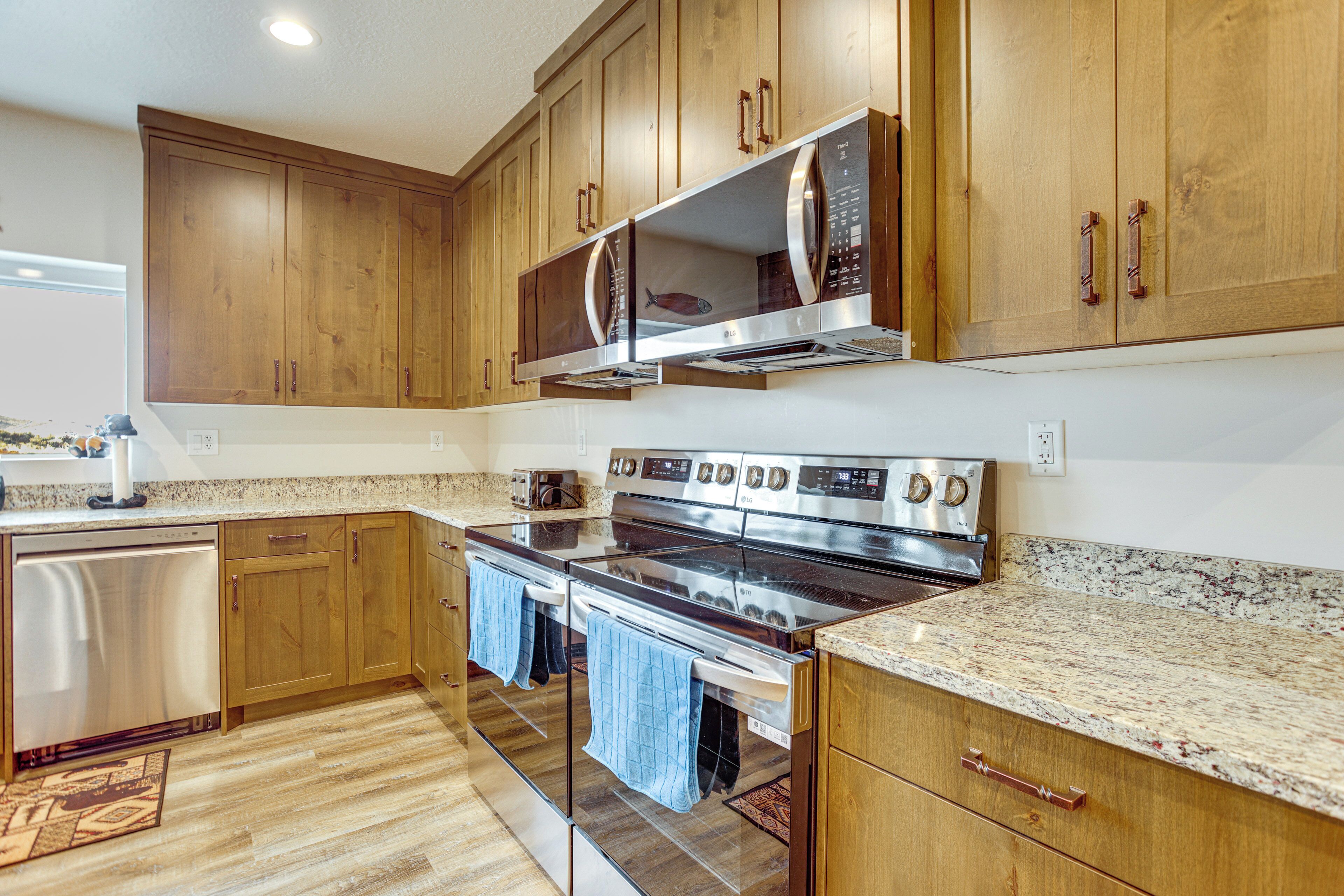 Una cocina moderna con gabinetes de madera, electrodomésticos de acero inoxidable y encimeras de granito.