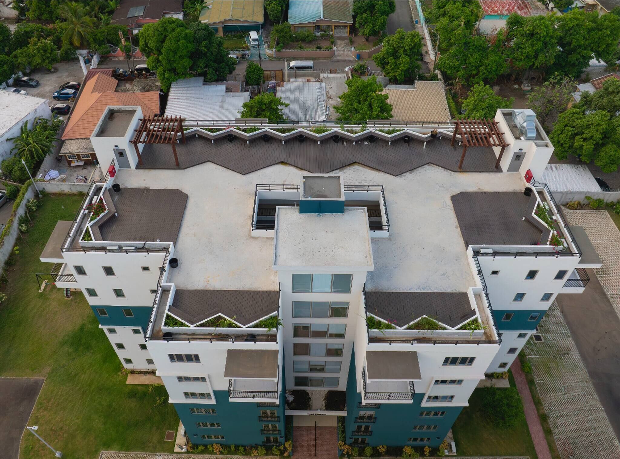 A multi-story building with a central courtyard, surrounded by greenery and other buildings.