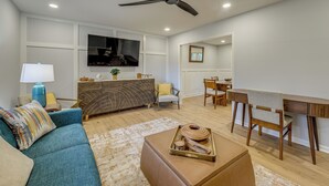 Ein modernes Wohnzimmer mit einer Couch, einem Couchtisch und einem Essbereich mit Tisch und Stühlen.