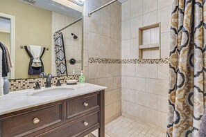 A bathroom with a double sink vanity, a shower with a glass door, and a tiled floor. - Golf, Paddle & Hike: Cozy Inverness Home w/ Yard (Inverness)