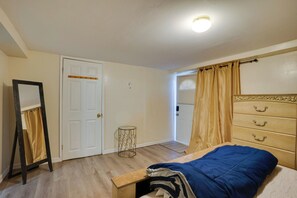 Un dormitorio con cama, cómoda, espejo y puerta.