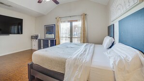 A bedroom with a bed, a ceiling fan, a window with curtains, a flat-screen TV, and a dresser. - Walk to Lake! Home w/ Pool Near At&t Stadium (Rowlett)