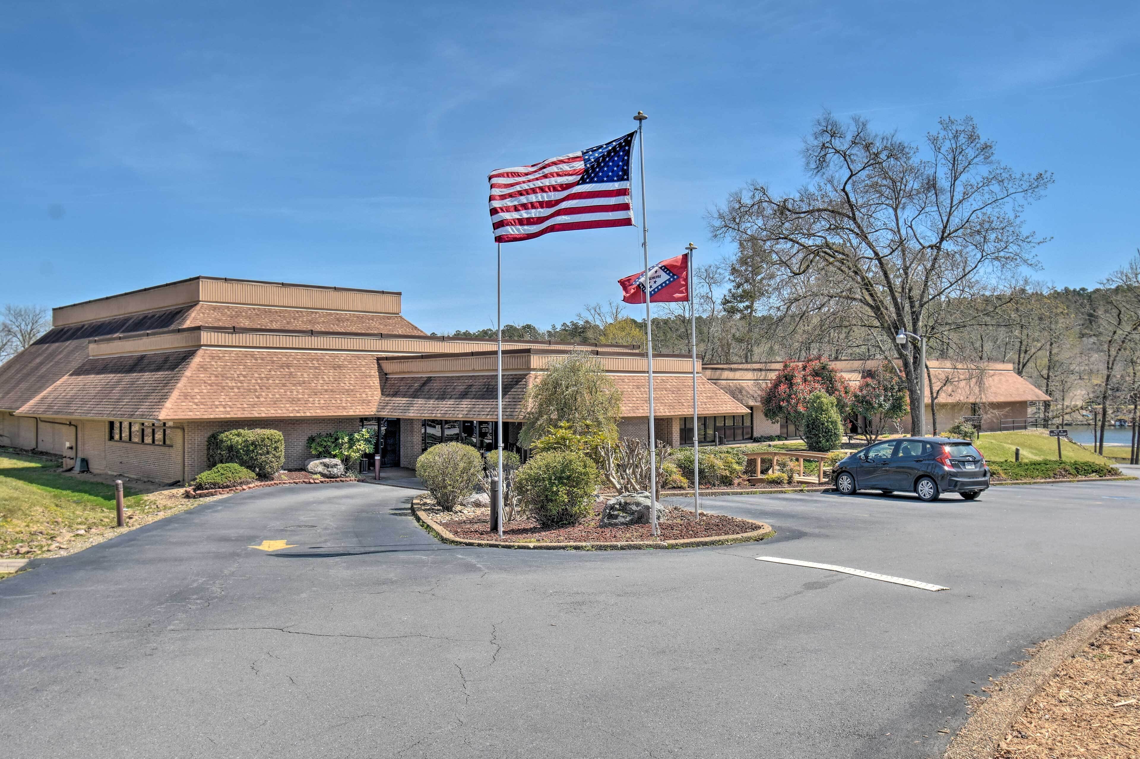 A building with a brick facade, a parking lot, and two flags.