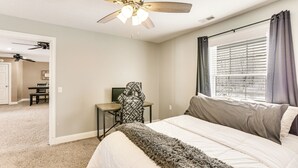 A bedroom with a bed, a desk, a chair, a ceiling fan, and a window with curtains. - Family Home on 9 Acres! Climbing Wall & Gym (Thornville)