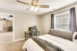 A bedroom with a bed, a desk, a chair, a ceiling fan, and a window with curtains. - Family Home on 9 Acres! Climbing Wall & Gym (Thornville)