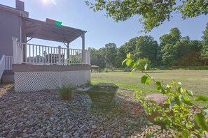 Un patio couvert avec des meubles d’extérieur, une clôture blanche et une pelouse.