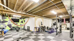 A gym with a checkered floor, exercise equipment, and a hammock. - Family Home on 9 Acres! Climbing Wall & Gym (Thornville)