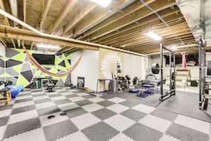 A gym with a checkered floor, exercise equipment, and a hammock. - Family Home on 9 Acres! Climbing Wall & Gym (Thornville)