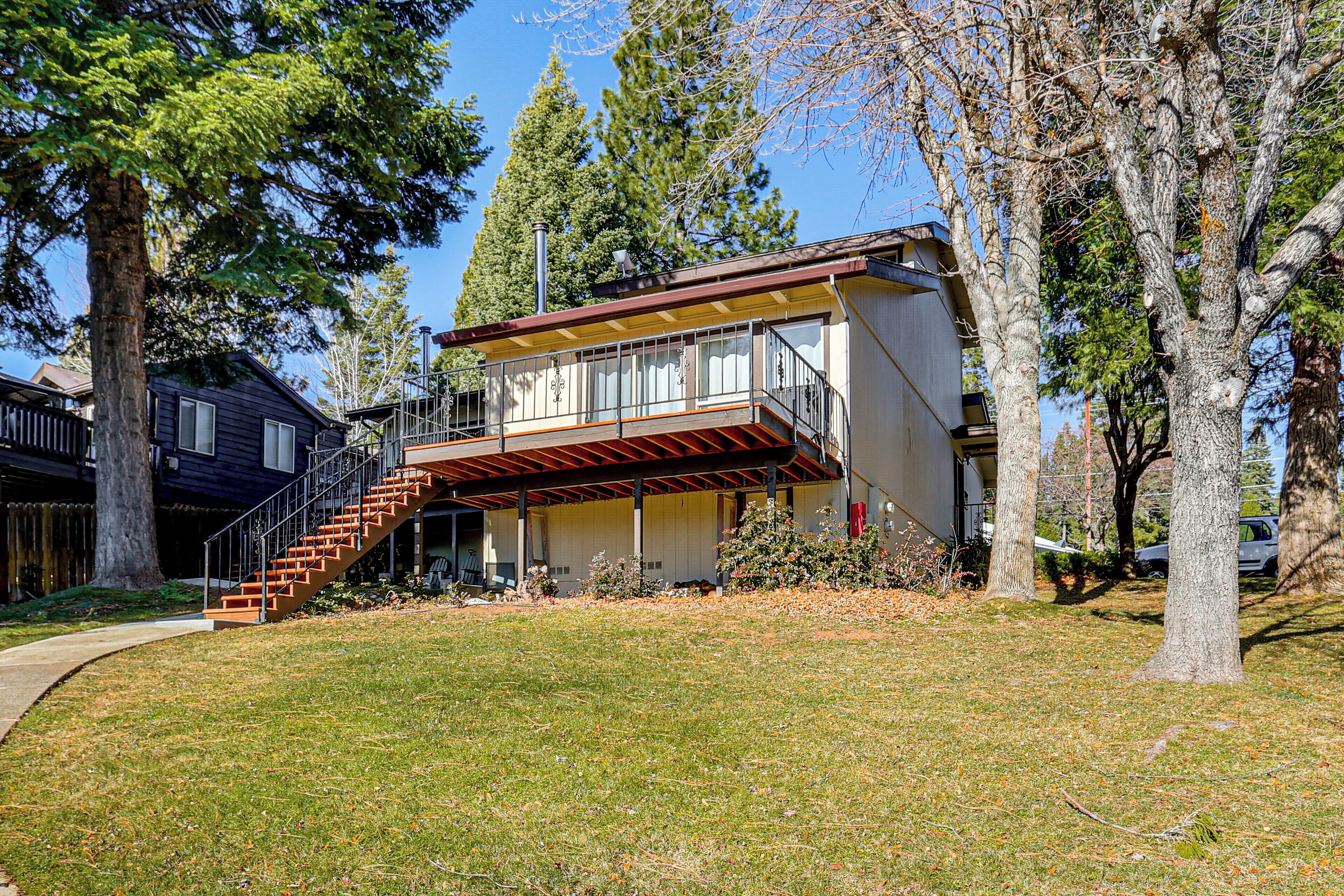 A two-story house with a balcony and a staircase leading to the entrance.