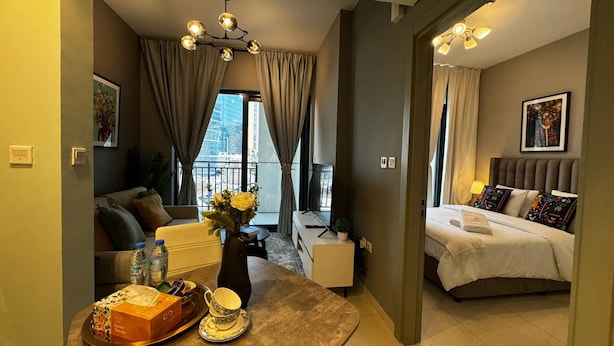Ett hotellrum med en säng, en sittgrupp med ett bord och utsikt över stadsbilden.