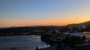 A nighttime view of a lakeside town with buildings and a bridge. - Sunny studio for 4 with balcony, lake view, and WiFi (Besse-et-Saint-Anastaise-Super Besse)