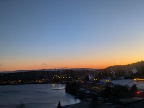 A nighttime view of a lakeside town with buildings and a bridge. - Sunny studio for 4 with balcony, lake view, and WiFi (Besse-et-Saint-Anastaise-Super Besse)