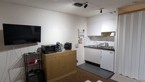 A compact living space with a flat-screen TV, a microwave, a coffee maker, and a small refrigerator. - Sunny studio for 4 with balcony, lake view, and WiFi (Besse-et-Saint-Anastaise-Super Besse)