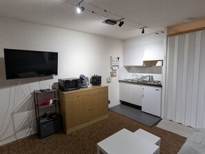 A compact living space with a flat-screen TV, a microwave, a coffee maker, and a small refrigerator. - Sunny studio for 4 with balcony, lake view, and WiFi (Besse-et-Saint-Anastaise-Super Besse)
